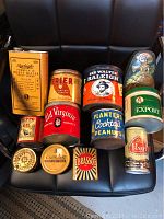 All 12 vintage collectible tins arranged together on a chair for clear viewing.