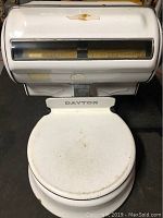 Close-up front view of the white porcelain round weighing platform marked 'DAYTON'.