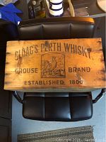 Top view of Cloag's Perth Whisky Grocery Brand wooden crate showing brand and established date with bird logo.
