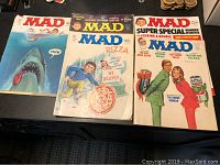 Five MAD Magazines spread out with three fully visible covers: shark theme, pizza delivery cartoons, and a special issue with characters exchanging oversized items.