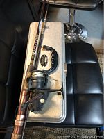 Closed gray Umco 175A metal tackle box with the fishing rod and reel placed on top