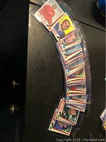 22 Topps vintage hockey cards arranged in a curved line, showing player portraits and team names. Cards are in protective plastic sleeves placed on a dark surface.