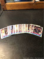 Spread of vintage WHA hockey cards arranged on black surface, showing card backs and fronts in a fan layout