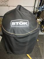 Covered BBQ with black STOK branded protective cover