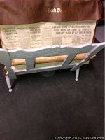 Brown protective case labeled "New York Times" with the 1928 newspaper showing front page text, resting on white wooden slatted stand.