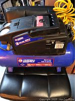 Campbell Hausfeld 3-gallon air compressor showing brand label and specifications
