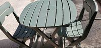 Close-up of green folding table with slatted top and matching chair