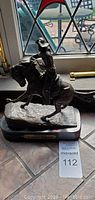 Full view of the bronze cowboy sculpture on marble base