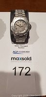 Front view of watch on display cushion with auction lot sheet visible