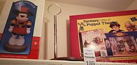 Photo of boxed Minnie Nutcracker, metal doll stand, and boxed Fantasy Puppet Theatre set.