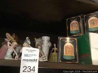 Shelf with ceramic/porcelain Disney princess and horse figurines and boxed Wizard of Oz miniature waterballs