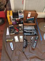 Overview photo showing all items including the Wagner Power Painter box, socket sets, clamps, door hinges, hand tools and small hardware grouped on floor.