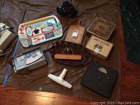 Photo showing multiple items including plastic tray, wicker basket, wooden cutting board, ceramic planter, decorative boxes, and bathroom scale.