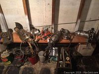 Photo shows pair of Skil tackpointing grinders, Stanley planer, Black & Decker finishing sander, and hardware in tins and containers on workbench.