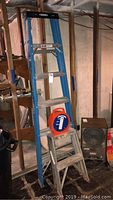Wide view showing Werner 6 foot ladder, small metal step ladder, Snap-It Stor-A-Cord cord winder on top of small ladder.
