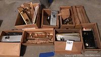 Overview of 8 boxes of vintage door hardware including knobs, handles, faceplates and locks