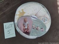Boppy Preferred Newborn Lounger in original packaging showing product branding and baby image on round pillow surface.