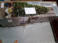 Boxed Winter Wonderland 7ft Christmas tree in storage with lot number attached.