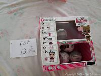 Photo showing the front of the unopened box with 3 visible LOL Surprise Glitter Series spherical containers inside, plus illustration of one doll on front.