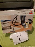 Box front showing product name, brand, and image of vacuum in use with features list and selling points