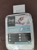 Front view of sealed Sealy Prestige Cooling Mattress Pad in original packaging, showing product branding and feature list.