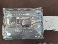 Photo of the clear plastic zippered packaging displaying the Gluckstein Home Greyson Bedding Collection 3-piece king duvet cover set.