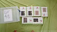 Clear plastic box with six Christmas card packs arranged on green fabric, labeled Lot 48