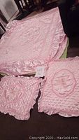 Photo showing light pink bedding set items including 1 bed cover and 2 pillow covers with ruffled edges and decorative patterns.