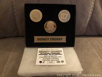 Bronze medallion set displayed on black velvet plaque with nameplate and authenticity certificate in front.