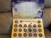 Open album showing 24 medallions with player portraits and historical team information background.