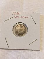 Reverse side of the 1920 Canadian five cent coin showing the wreath and denomination in a protective holder.