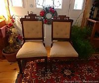 Photo of both Victorian Eastlake parlor chairs showing walnut wood frame and upholstery.
