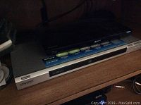Sony DVD player DIP-NS55P silver model with front disc tray and buttons.