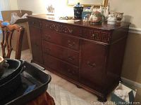 Full view of vintage wooden server showing top surface, three drawers, two cabinet doors, and ornate detailing on front
