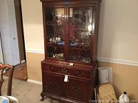 Full view of vintage wooden hutch with glass doors and drawers in lower cabinet.