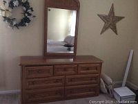 Full view of Thomasville wooden dresser and attached mirror, showing overall shape and design.