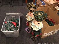 Photo showing two tall metal nutcracker figures standing side by side, painted with festive colors including gold, red, green, and black.
