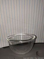 Close-up image of one of the small clear glass bowls, showing shape and size against a lined background for scale.