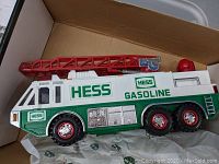 Photo showing Hess Gasoline toy fire truck with red ladder and six wheels in shoebox.