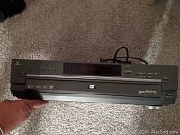 Front view of DVD player showing control buttons, display panel, and DVD logo.