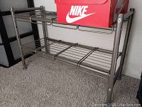 Metal adjustable shoe rack shown with a red Nike shoe box on top to indicate size and usage.