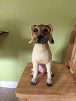 Front view of the plaster of Paris dog figurine, showing the detailed painted face and natural brown colors.
