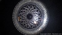 Top view of round crystal serving dish showing starburst central pattern with diamond cut outer design.