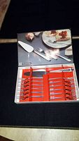 Photo showing the opened cake serving set case with cake server, knife, and 12 forks inside.