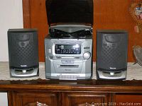 Full view of Venturer 5 CD mini hi-fi system with two speakers placed on a wooden surface, showing the open CD changer top and front panel controls.