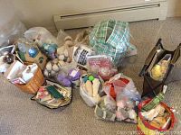 Overview photo of all knitting supplies including yarn piled in bags, baskets, and a foldable stand with yarn keeper and other tools visible.