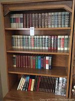 Wooden bookcase with multiple shelves holding various vintage hardcover book sets, mainly Readers Digest and Time Life collections.