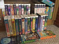 Front view of a collection of VHS tapes featuring Disney and other children's movies. Titles include Aladdin, Bambi, The Aristocats, and Shirley Temple movies among others.