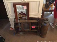 United Cigar Stores wall mirror with painted glass and wooden frame leaning behind cabinet