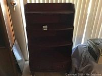 Front view of the wood shelf with two drawers, showing overall condition and wear including chipping.